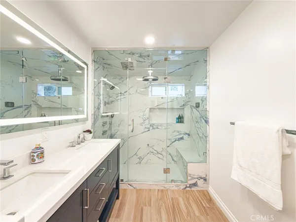 a spacious bathroom with a double vanity sink a mirror and a shower