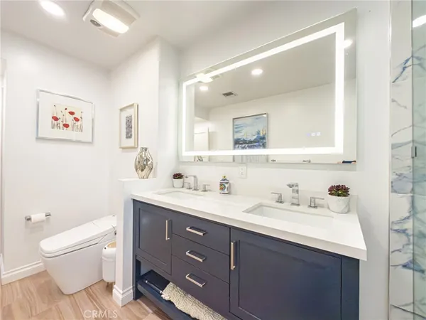 a bathroom with a toilet a sink a mirror and a shower