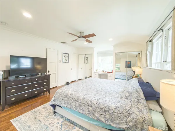 a spacious bedroom with a bed and a flat screen tv