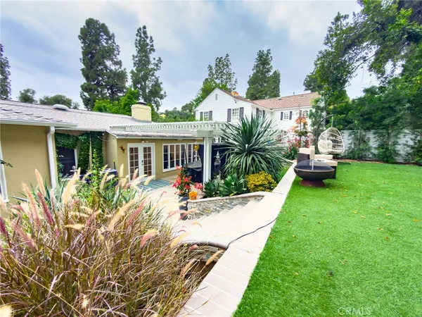 a view of a house with backyard sitting area and garden