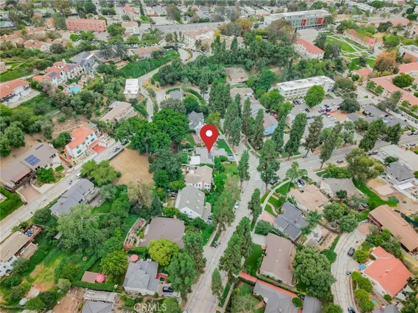 an aerial view of residential houses with outdoor space and trees
