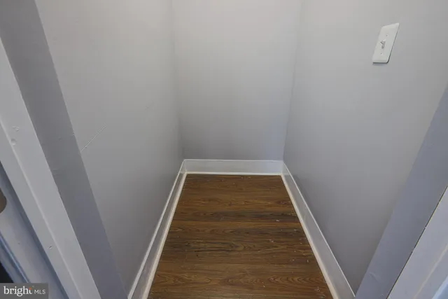 an empty room with wooden closet and windows
