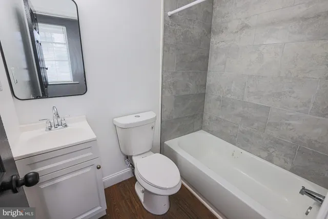 a bathroom with a toilet a sink and mirror