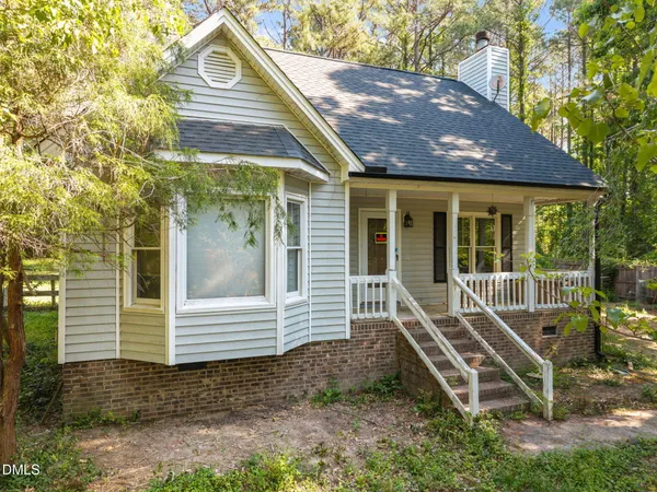 a view of house with a yard and wooden fence