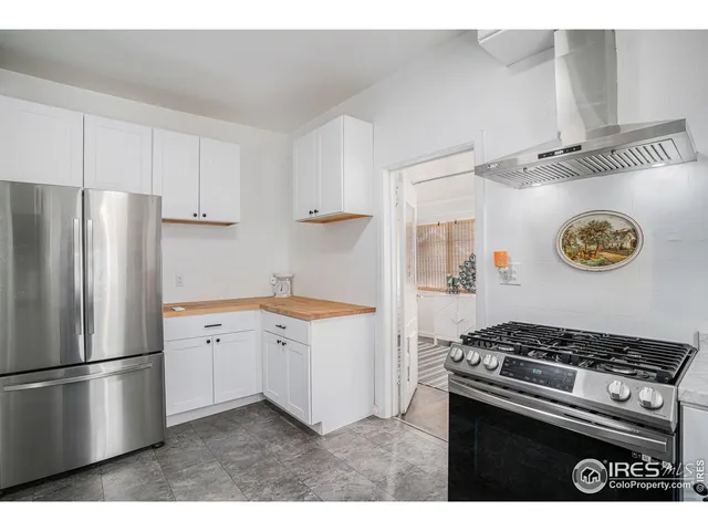 a kitchen with stainless steel appliances granite countertop a refrigerator and a stove