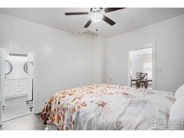 a bedroom with a bed and painting on the wall
