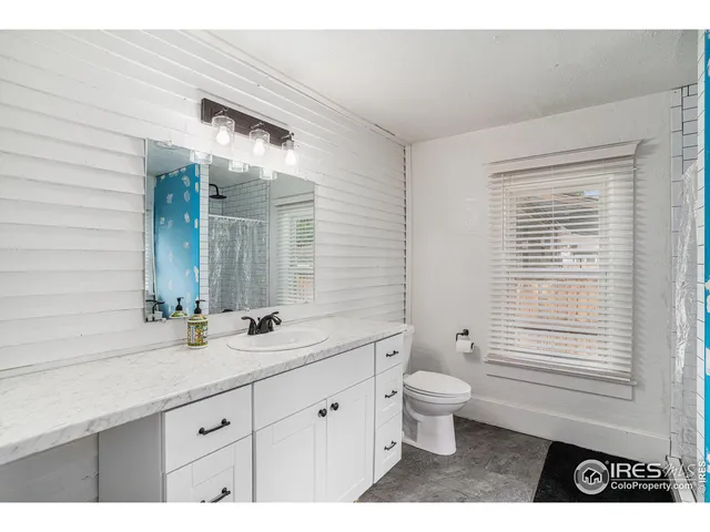 a bathroom with a double vanity sink toilet and a window