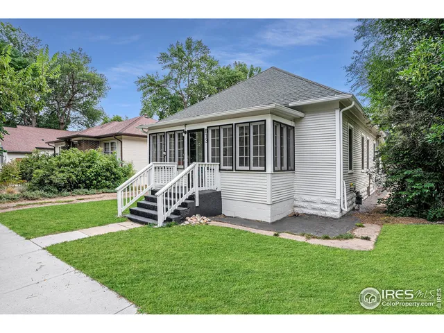 a view of a house with a yard and sitting area