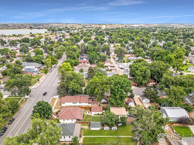 an aerial view of residential houses with outdoor space and trees