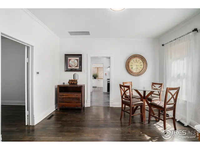 a view of a dining room and livingroom with furniture wooden floor and a clock