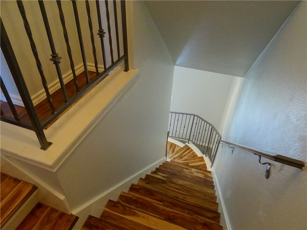 2918 Ranch Road 620, Unit K170 Austin, TX 78734 - Photo 13 of 22 Rich hardwood steps descend elegantly, framed by classic wrought iron railings leading to the lower level.
