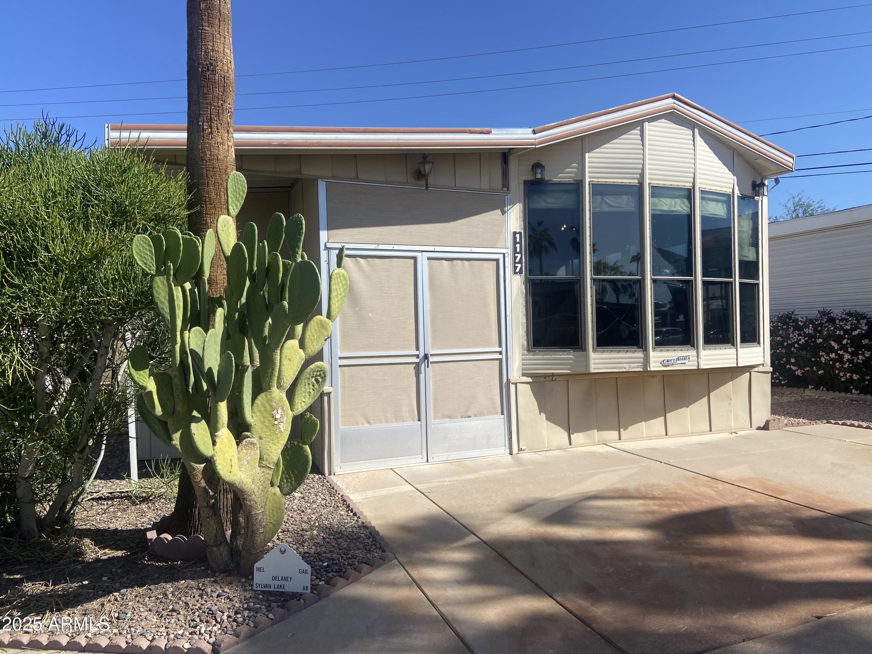 1177 Kiowa Circle Apache Junction, AZ 85119 - Photo 1 of 24 a house with a large window and yard with wooden floor