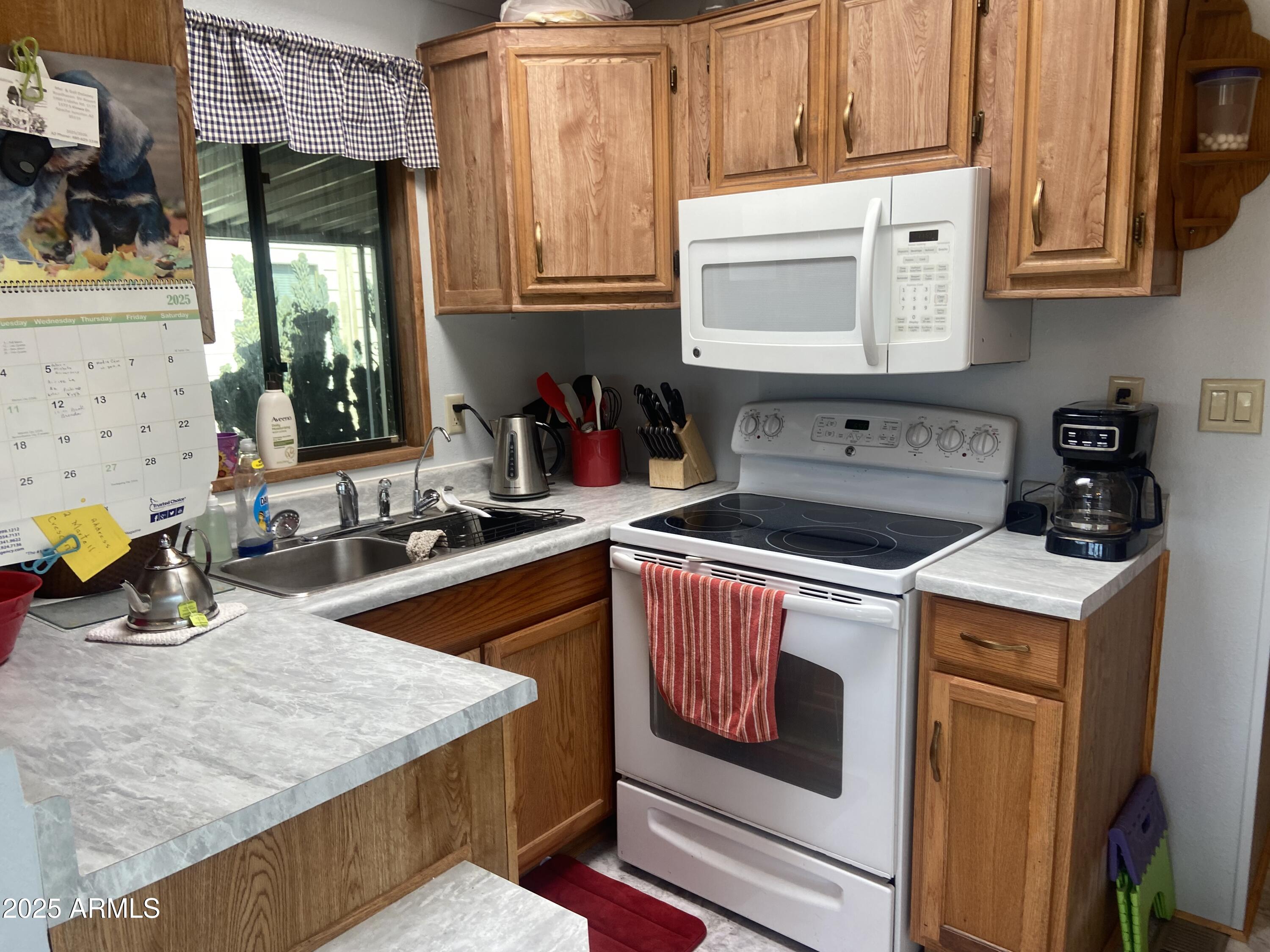1177 Kiowa Circle Apache Junction, AZ 85119 - Photo 8 of 24 a kitchen with a stove a sink and a microwave