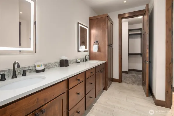 a bathroom with double sink and a mirror