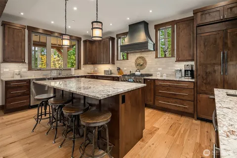 a kitchen with granite countertop a sink appliances and wooden floor