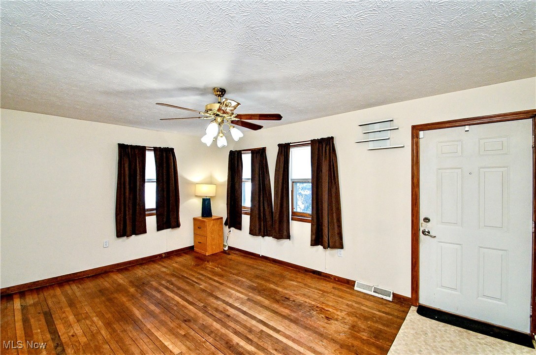 630 Neal Road Akron, OH 44312 - Photo 8 of 15 Living room with a textured ceiling, ceiling fan, and dark hardwood / wood-style floors