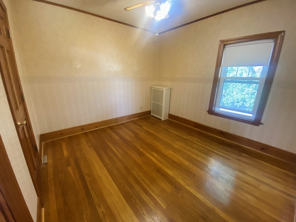 7 River St Place Lynn, MA 01905 - Photo 11 of 16 a view of an empty room with wooden floor and a window