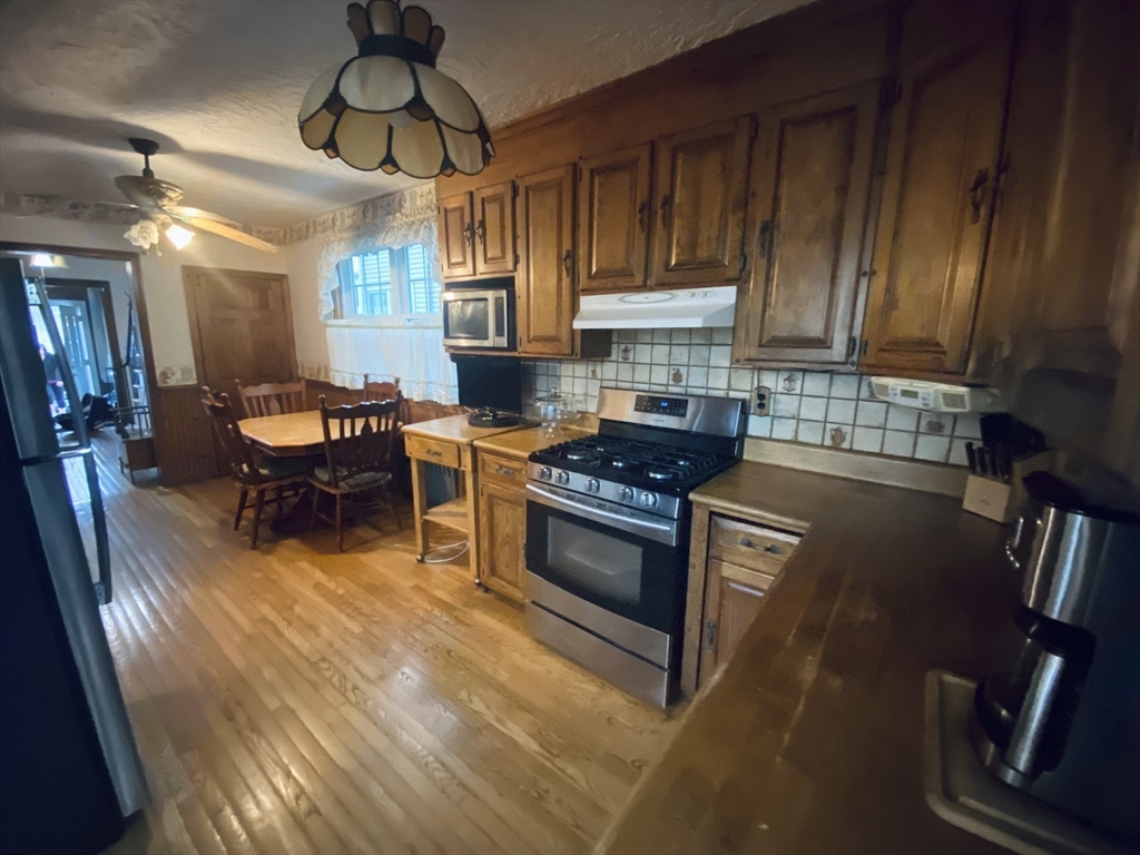 7 River St Place Lynn, MA 01905 - Photo 4 of 16 a kitchen with stainless steel appliances a stove a sink dishwasher and cabinets with wooden floor