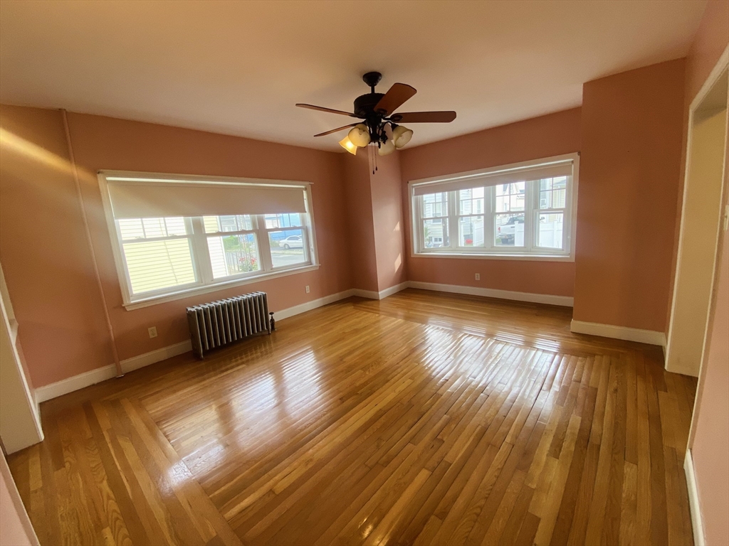 7 River St Place Lynn, MA 01905 - Photo 7 of 16 a view of an empty room with a window and wooden floor