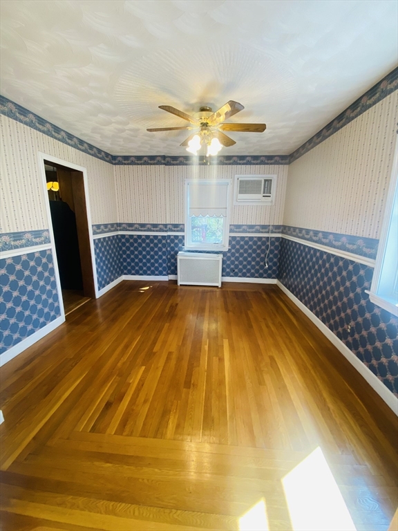 7 River St Place Lynn, MA 01905 - Photo 8 of 16 a bedroom with a bed and wooden floor