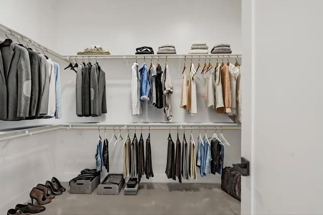 a view of walk in closet with clothes and shoes