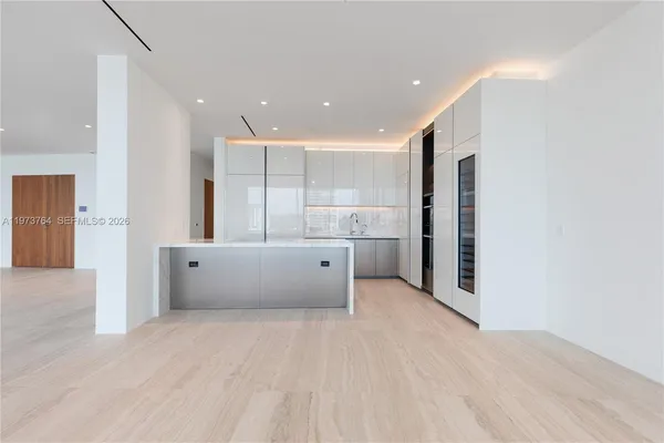 a view of kitchen with kitchen island granite countertop cabinets and refrigerator