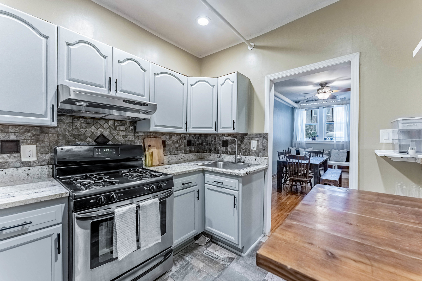 6430 North Glenwood Avenue, Unit G4 Chicago, IL 60626 - Photo 17 of 33 a kitchen with stainless steel appliances a stove a sink cabinets and a wooden floor