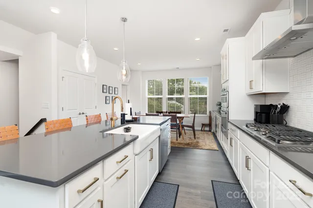 a kitchen with counter top space a sink stainless steel appliances and windows