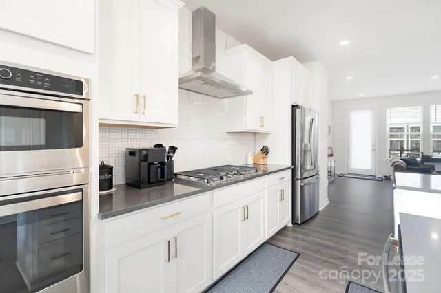 a kitchen with stainless steel appliances a stove refrigerator sink and cabinets