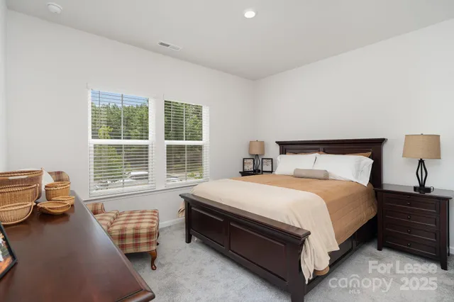 a large bed sitting in a bedroom next to a window with dresser