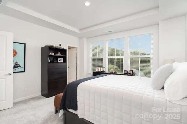 a large bed sitting in a bedroom next to a window