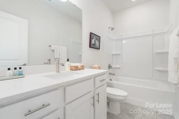 a bathroom with a granite countertop sink mirror vanity and toilet