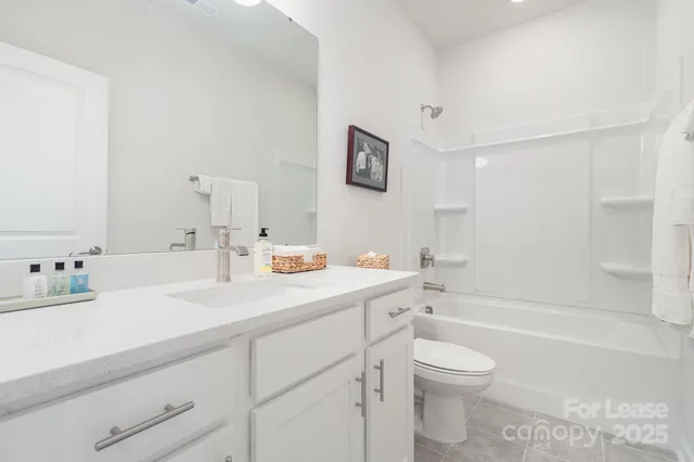 a bathroom with a granite countertop sink mirror vanity and toilet