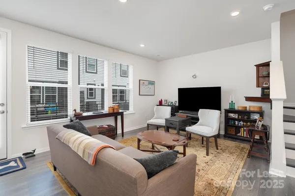 a living room with furniture a flat screen tv and large window