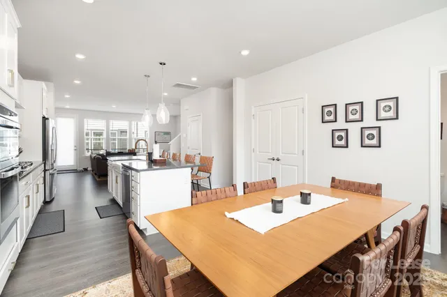 a open dining room with stainless steel appliances kitchen island a table and chairs