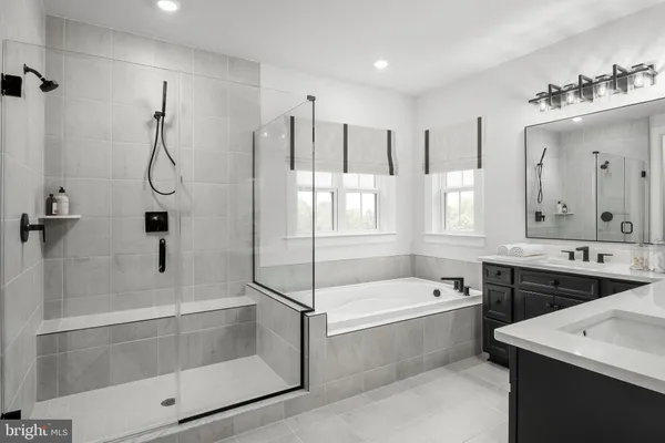 a bathroom with a tub sink and mirror