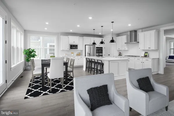 a living room with stainless steel appliances furniture and a view of kitchen