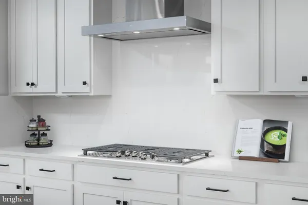 a kitchen with white cabinets and appliances
