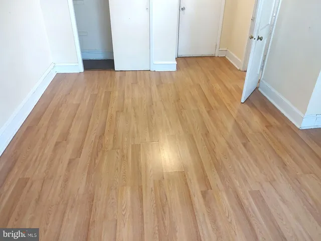 a view of empty room with wooden floor