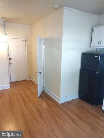 an empty room with wooden floor and cabinet