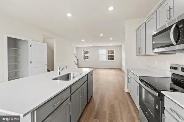 a kitchen with stainless steel appliances granite countertop a sink stove and cabinets