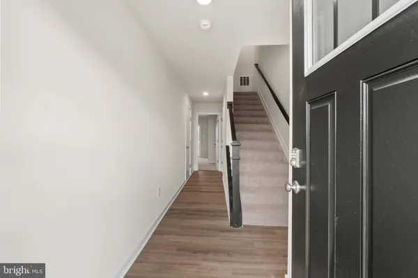 a view of entryway and hall with wooden floor