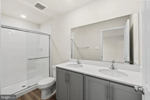 a bathroom with a sink toilet a mirror and shower