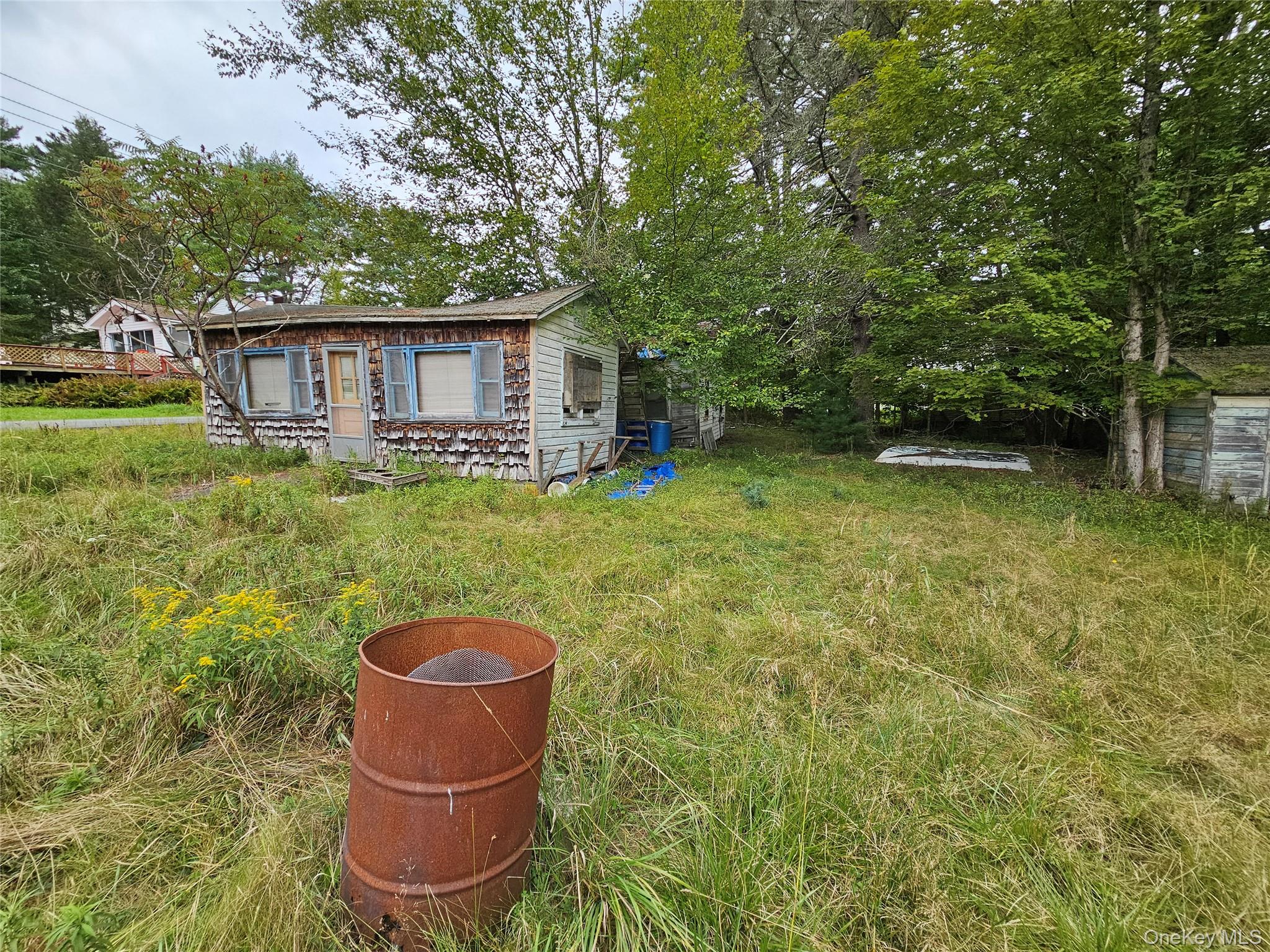 3624 State Rte 55 Kauneonga Lake, NY 12749 - Photo 33 of 40 a backyard of a house with table and chairs potted plants and large tree