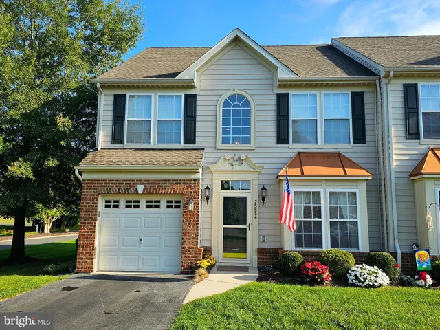 a front view of a house with a garden and plants
