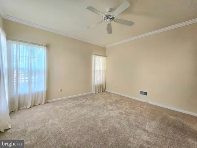 an empty room with a ceiling fan and a window