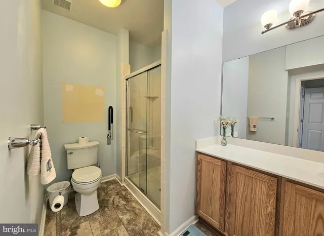 a bathroom with a granite countertop toilet a sink and a mirror