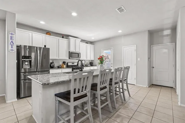 a kitchen with stainless steel appliances granite countertop a refrigerator and a stove top oven