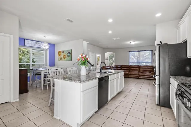 a kitchen with stainless steel appliances granite countertop a refrigerator and a stove