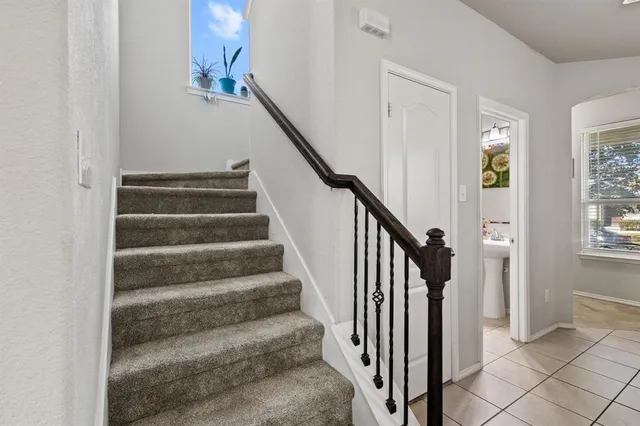 a living room with furniture two large window and a flat screen tv